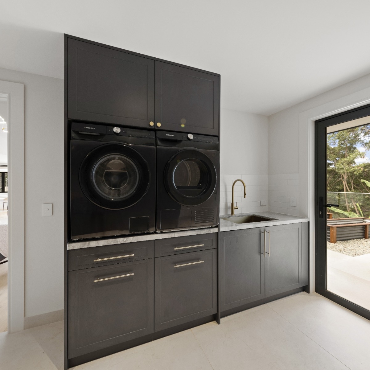 Black laundry with brushed brass fittings