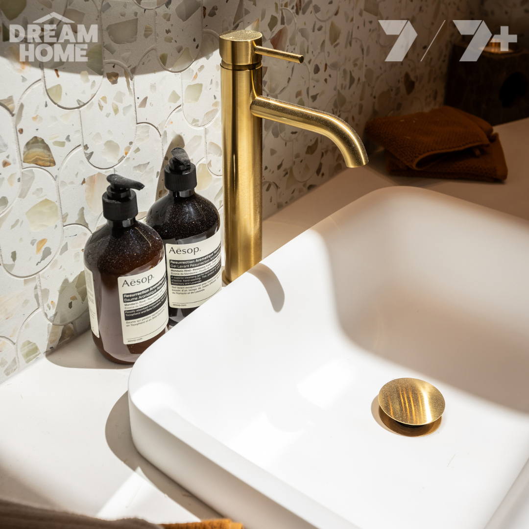 Brushed brass tapware with matte white basin